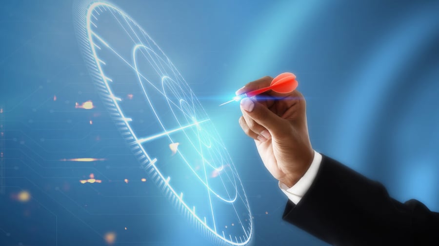 Hand of a businessman throwing a dart to an augmented reality graphic of a dart board