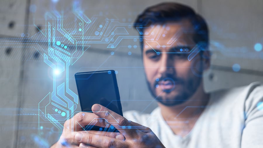 Young business person looks at their mobile device with interest and a graphic of data modules frame around him